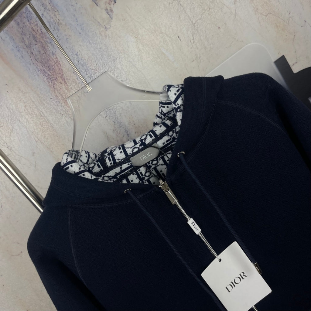 Navy zip-up hooded jacket with black-and-white printed interior and zipper