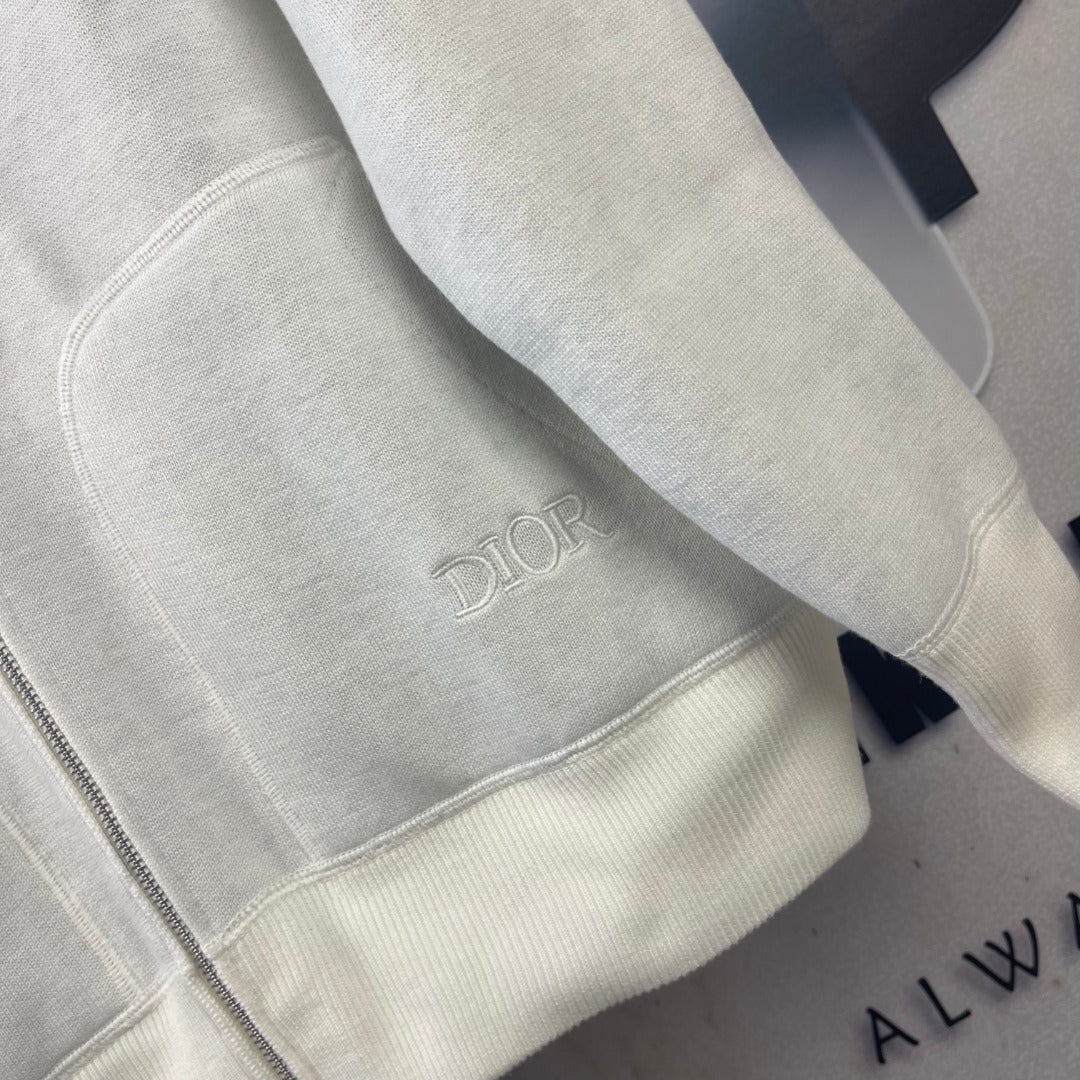 Dior long hoodie sleeve close-up with small embroidered Dior logo on off-white cuff