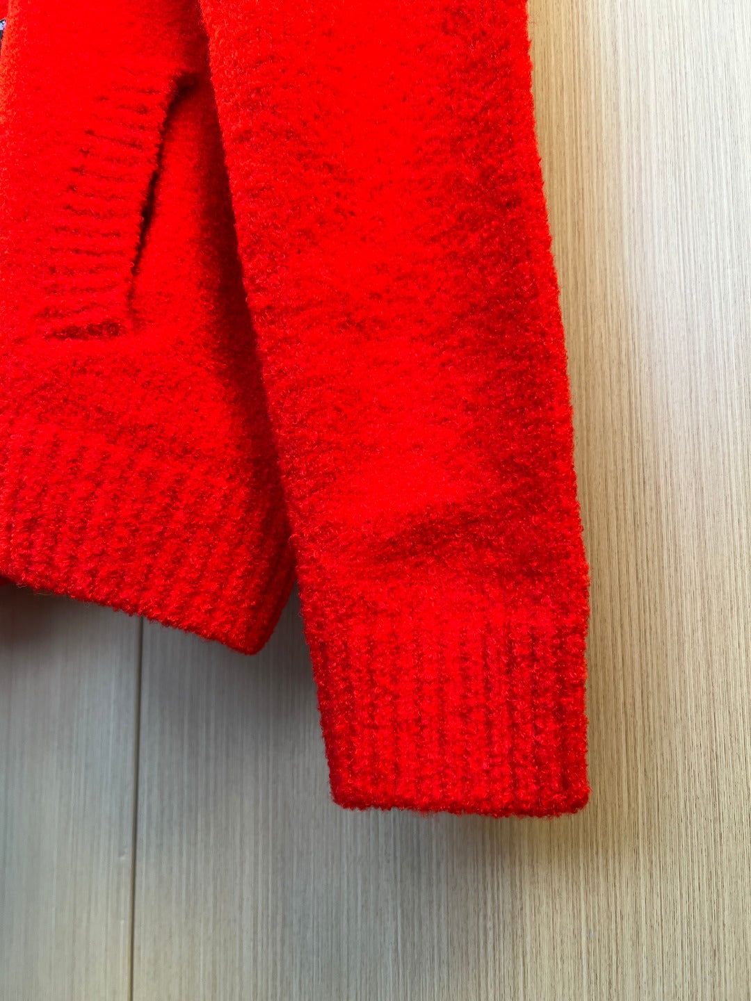 Red knit cardigan sleeve cuff with ribbed texture