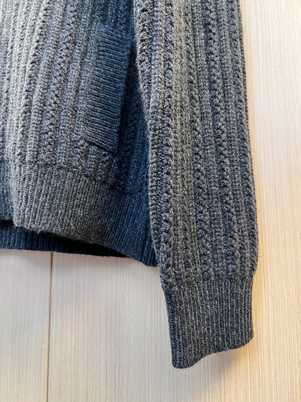Dark knit sweater hem with ribbed texture and side seam detail