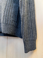 Dark knit sweater hem with ribbed texture and side seam detail