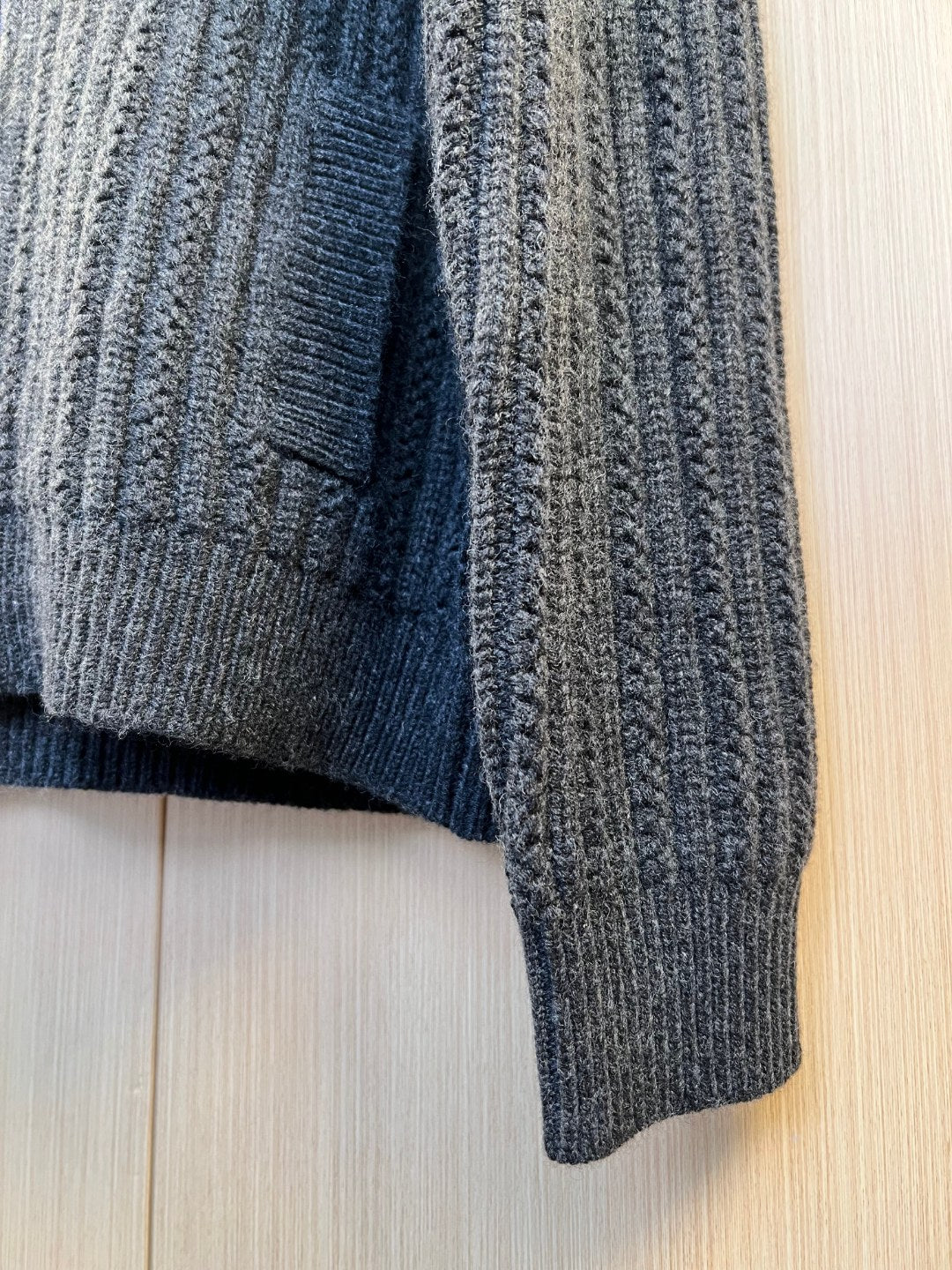 Dark knit sweater hem with ribbed texture and side seam detail