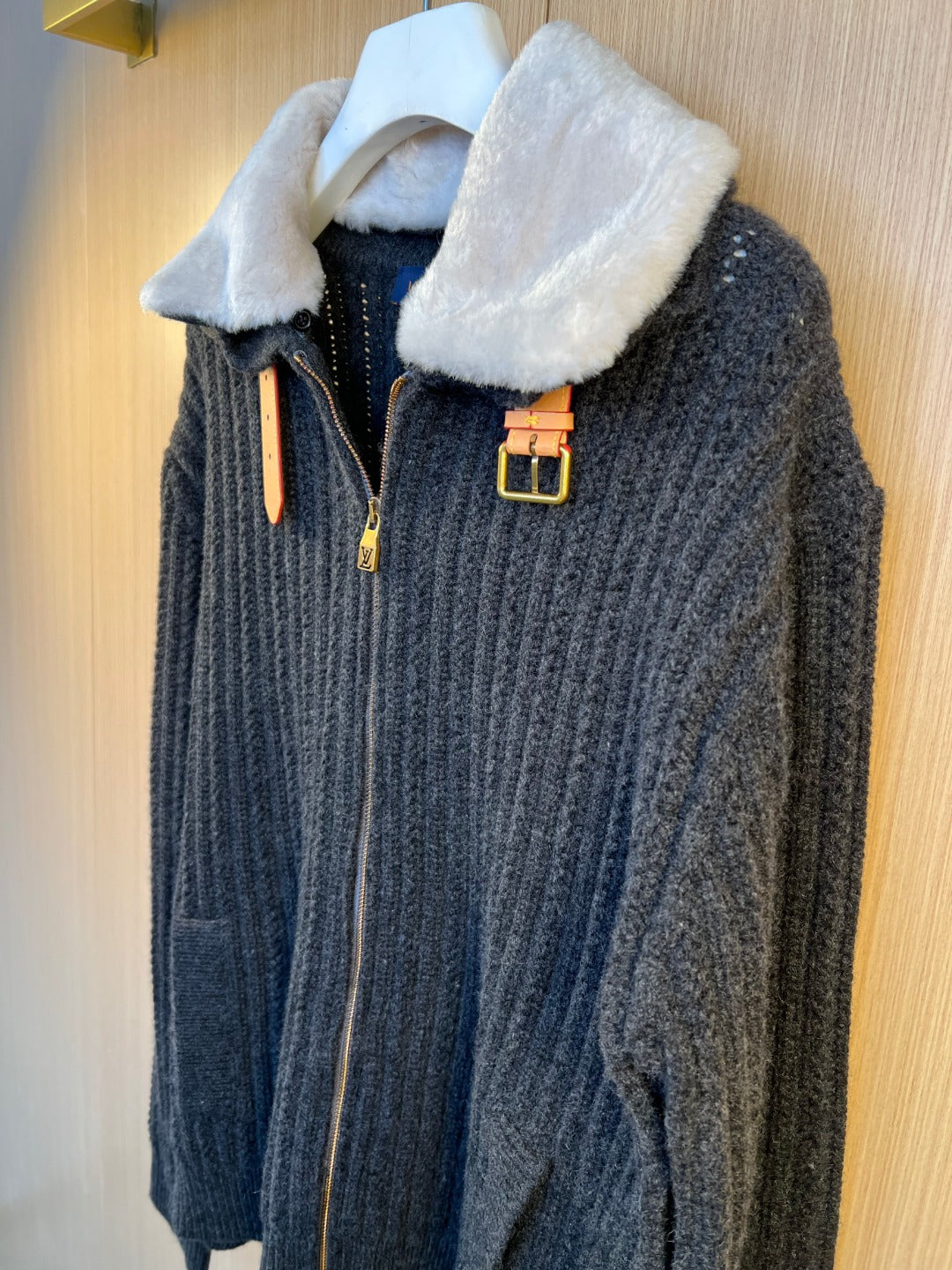 Dark knit jacket with faux fur collar and front zipper, gold-tone buckle accents