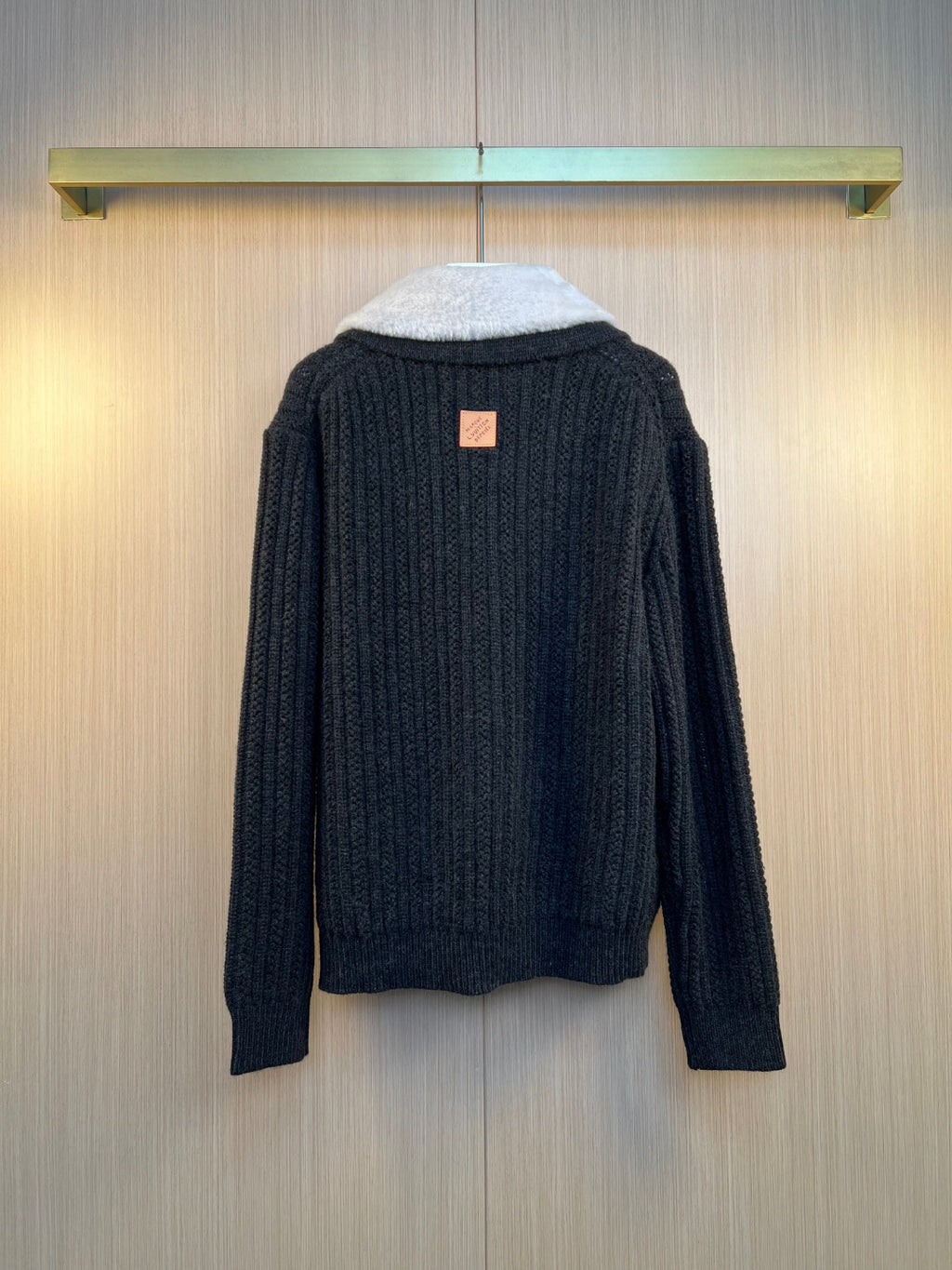 Dark knit jacket with ribbed cuffs and small orange Louis Vuitton label at back
