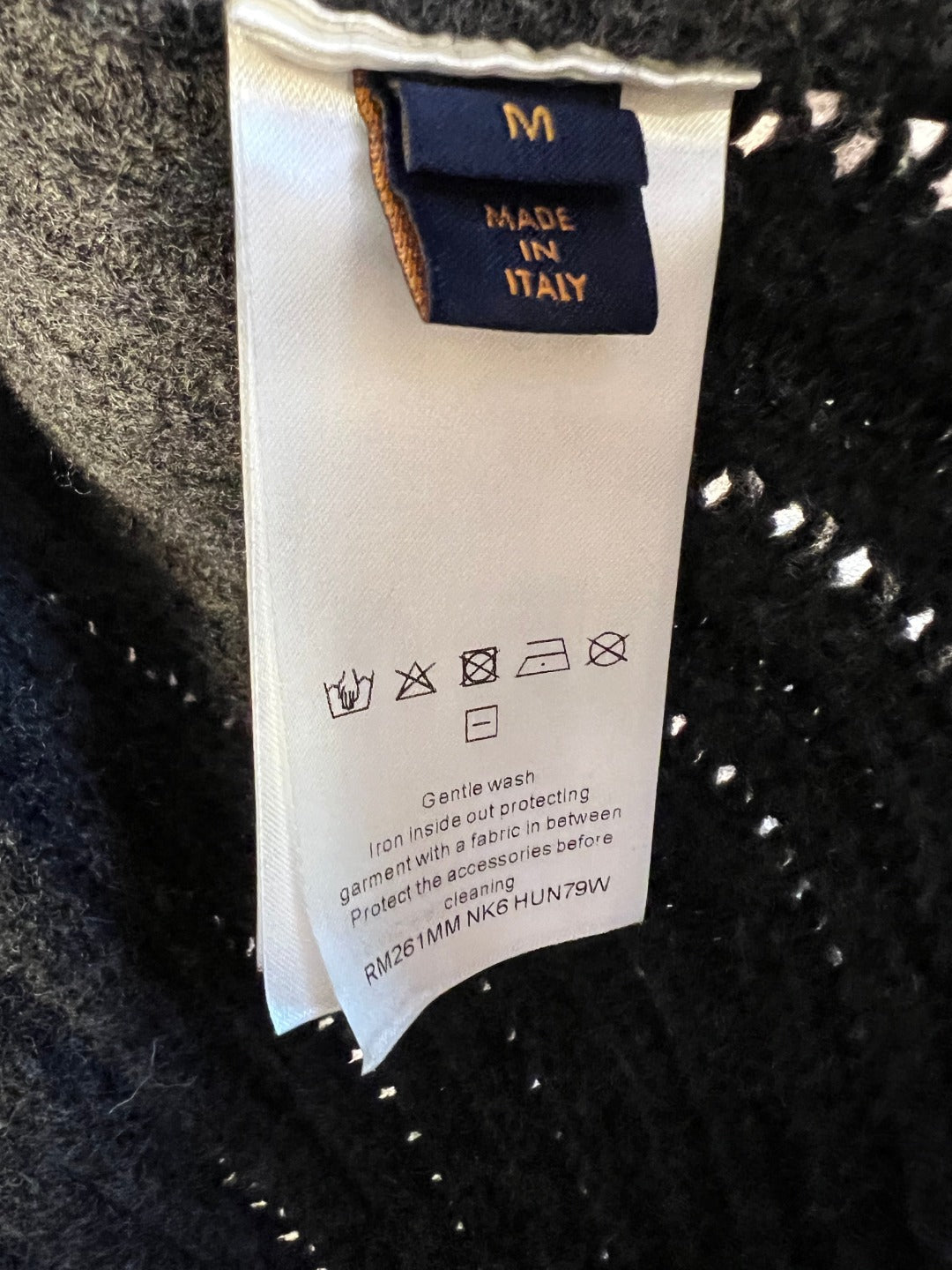 Inside care label on dark knit jacket, size M, Made in Italy