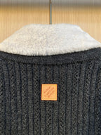Orange Louis Vuitton patch on dark knit back near the neckline