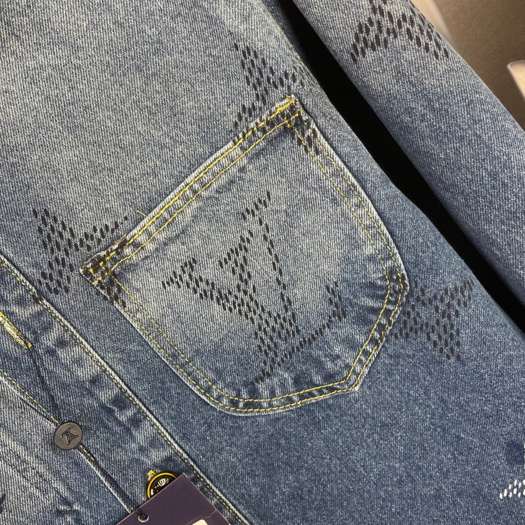 Denim jacket pocket close-up, embroidered pattern, yellow topstitch, button area
