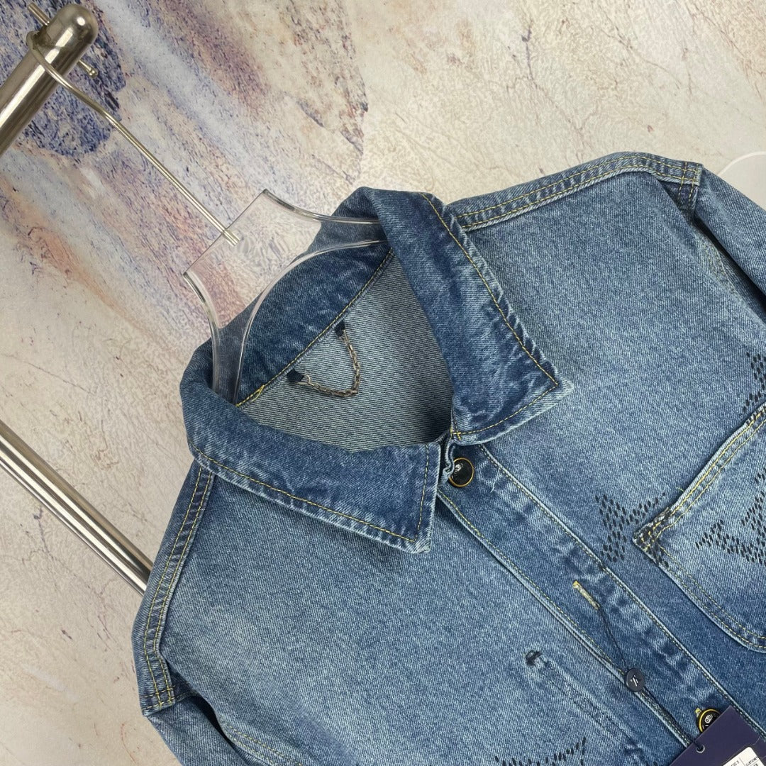 Denim jacket close-up, blue wash, chest pocket, seam details, button area