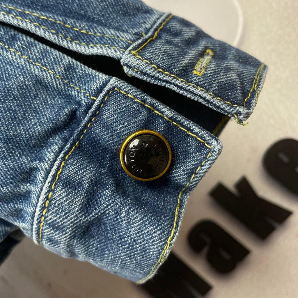 Denim jacket pocket and cuff close-up, round buttons, yellow contrast stitching