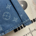 Denim jacket side view, blue wash, embroidered icons, long sleeve hem