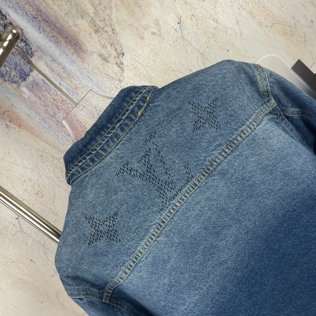 Denim jacket back yoke close-up, blue wash, embroidered motifs, seam detailing