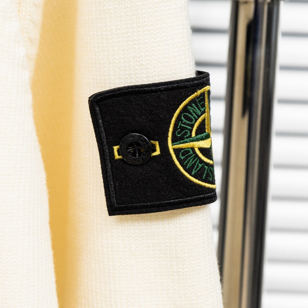 Stone Island cream knit cardigan sleeve patch with black fabric and yellow logo