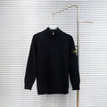 Black knit button-up jacket with high collar on hanger