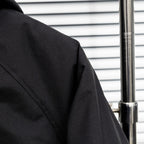 Stone Island jacket shoulder and side panel seam, dark textured fabric
