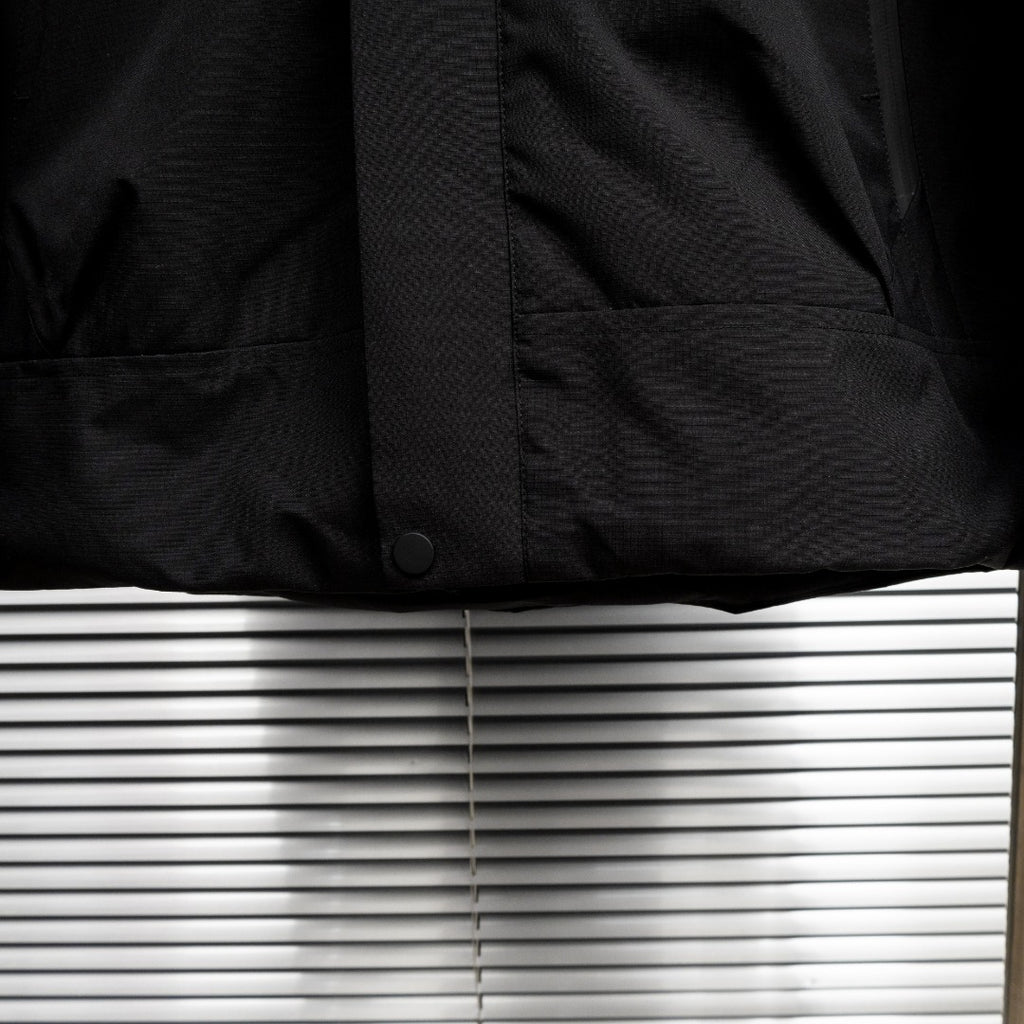 Stone Island jacket lower front close-up with snap button and pocket panel