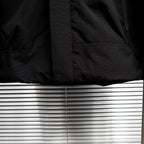 Stone Island jacket lower front close-up with snap button and pocket panel