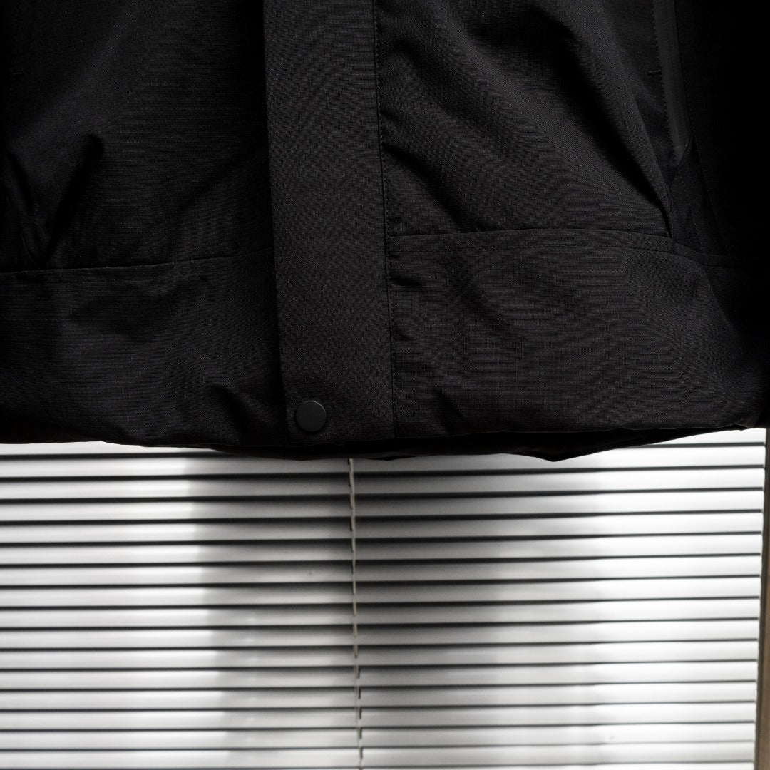 Stone Island jacket lower front close-up with snap button and pocket panel