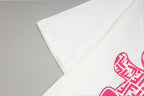 White T-shirt sleeve with partial pink bear graphic
