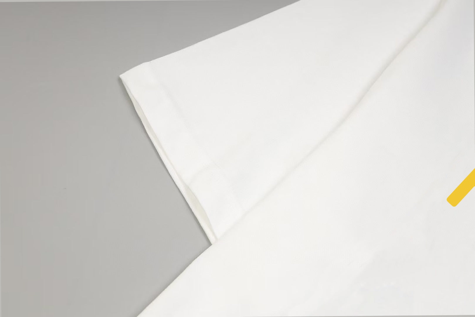 White short-sleeve T-shirt sleeve and folded hem detail