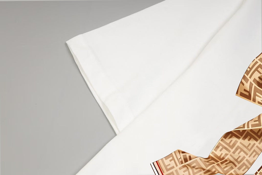 White T-shirt fabric close-up with part of the monogram bow