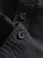 Dior long-sleeve shirt button close-up with black fabric texture