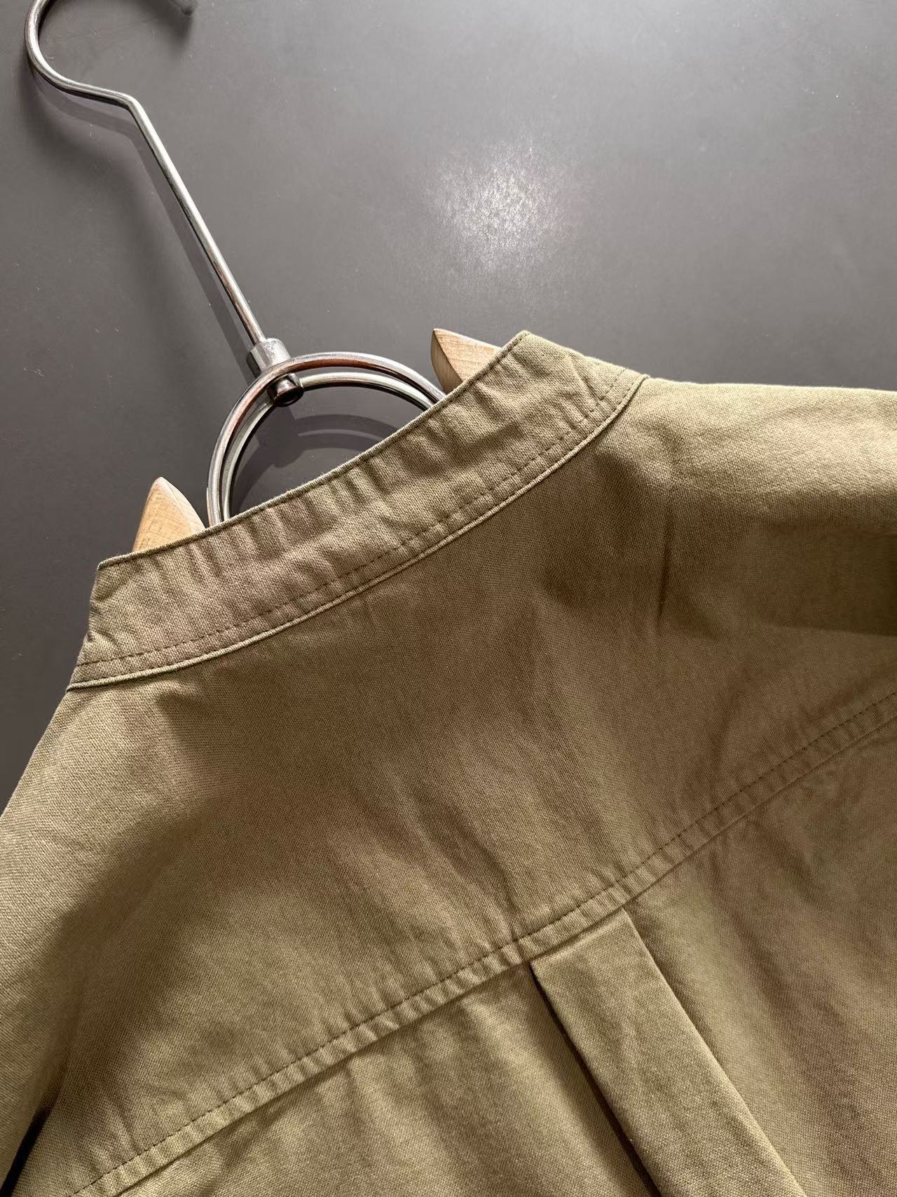 Long-sleeve shirt back yoke and top placket, olive-brown fabric.