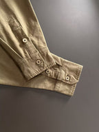 Long-sleeve shirt cuff with button tabs, olive-brown fabric.