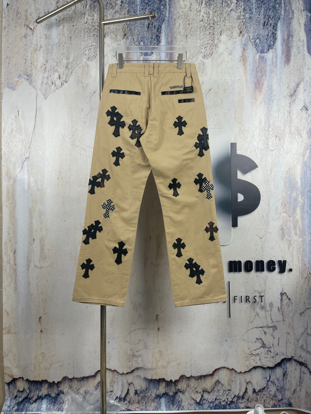 Tan cargo-style pants with black embroidered cross motifs, back view.