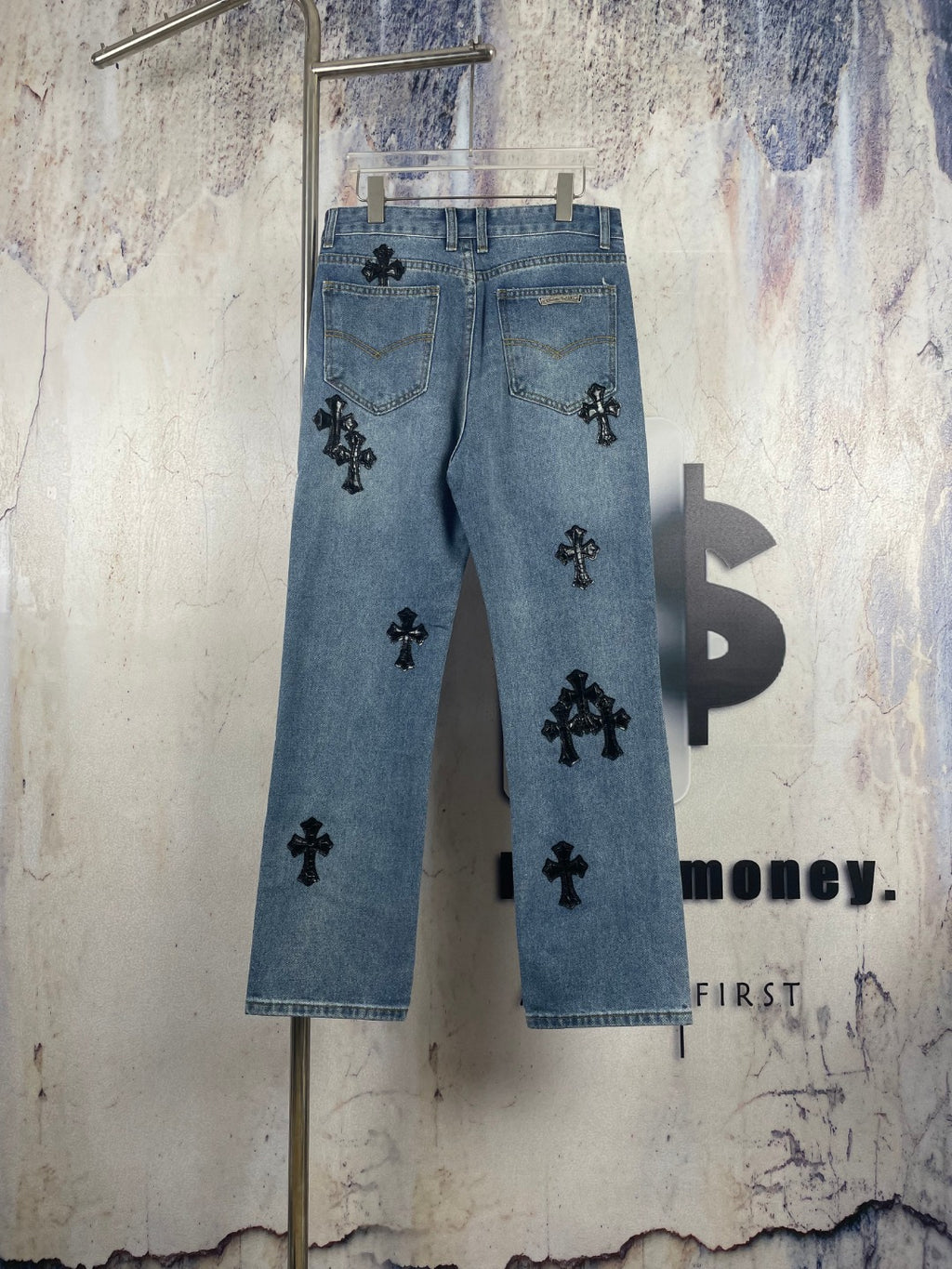 Light blue denim pants with black cross appliques and scattered front graphics