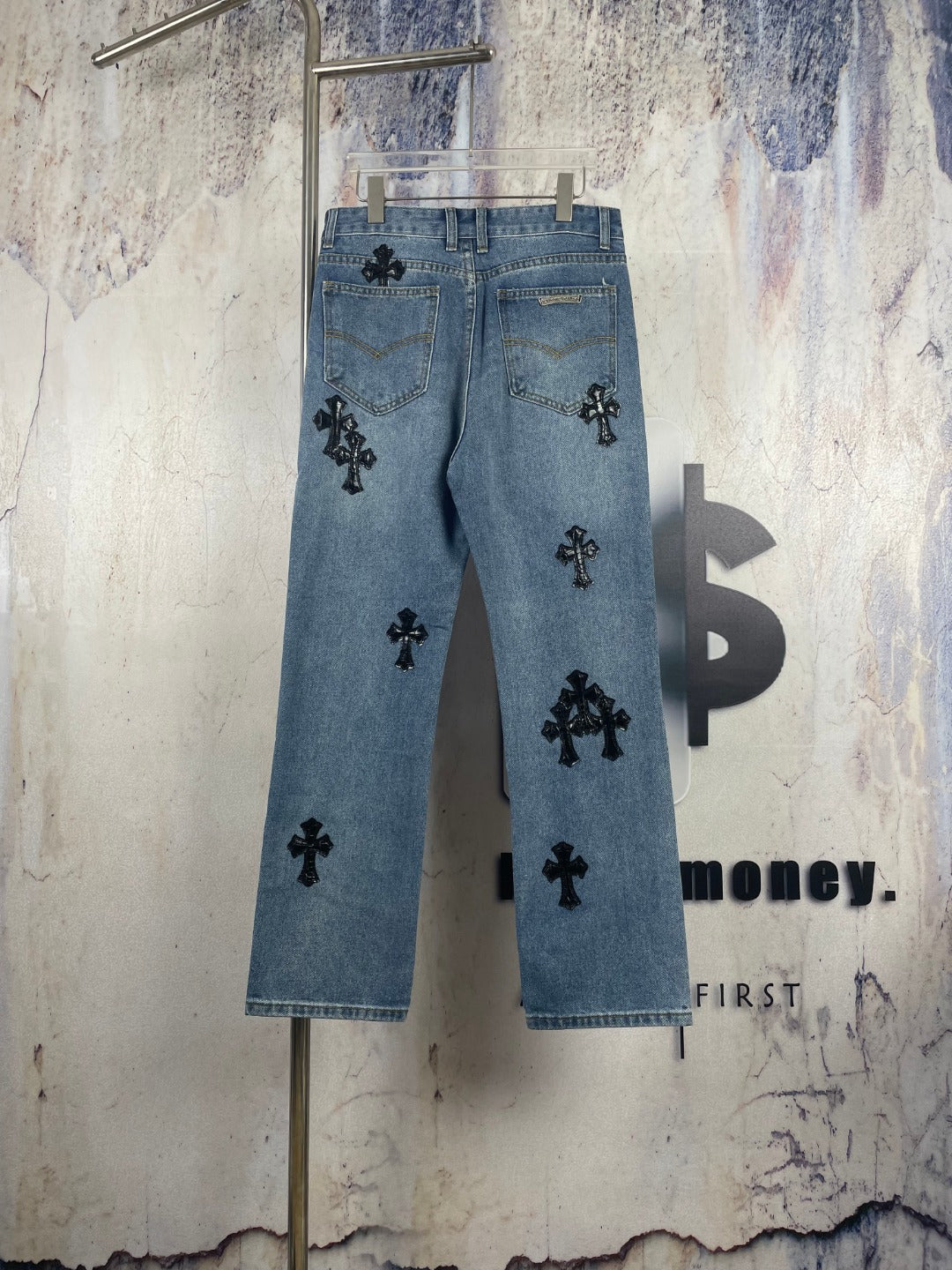 Light blue denim pants with black cross appliques and scattered front graphics