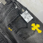 Dark denim pants close-up of back yoke area and yellow cross patch