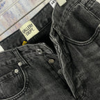 Dark gray denim pants close-up of pocket and waistband hardware
