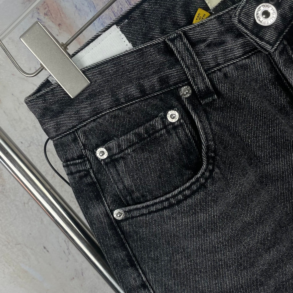 Dark gray denim pants close-up of back pockets and button stitching
