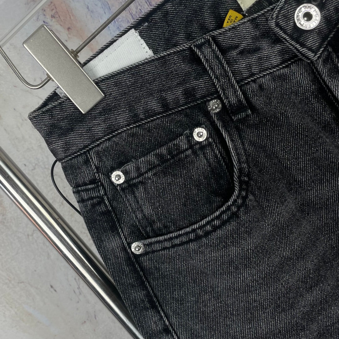 Dark gray denim pants close-up of back pockets and button stitching