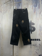Black wide-leg pants with gold cross patches and small dark cross appliques