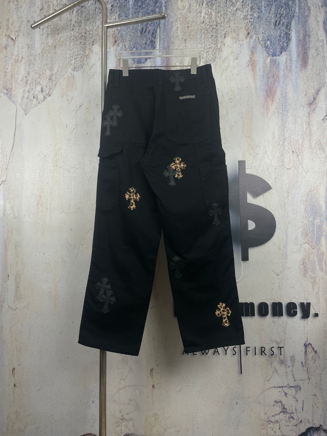 Black wide-leg pants with gold cross patches and small dark cross appliques