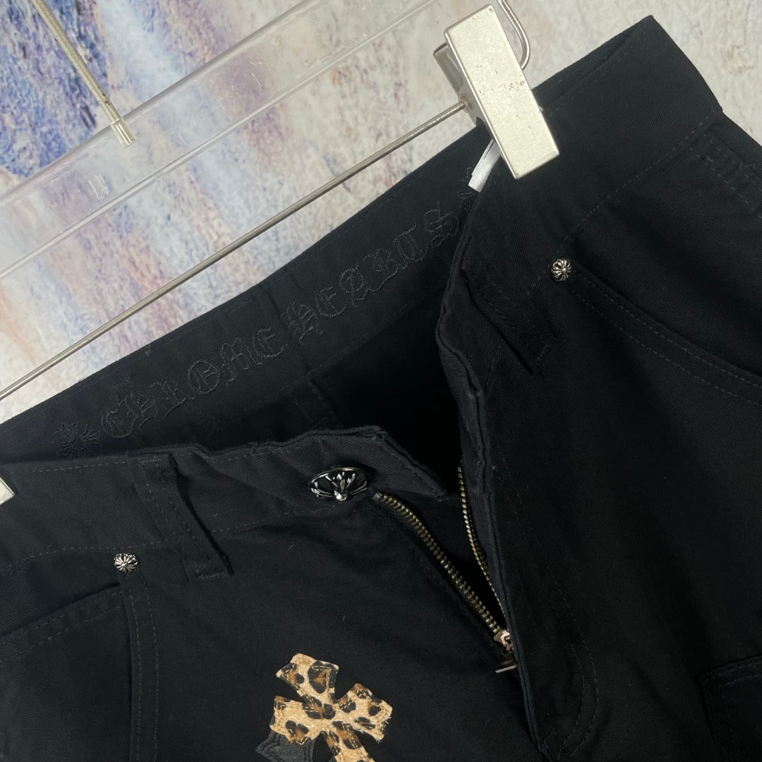 Black pants with front zipper detail and gold cross applique