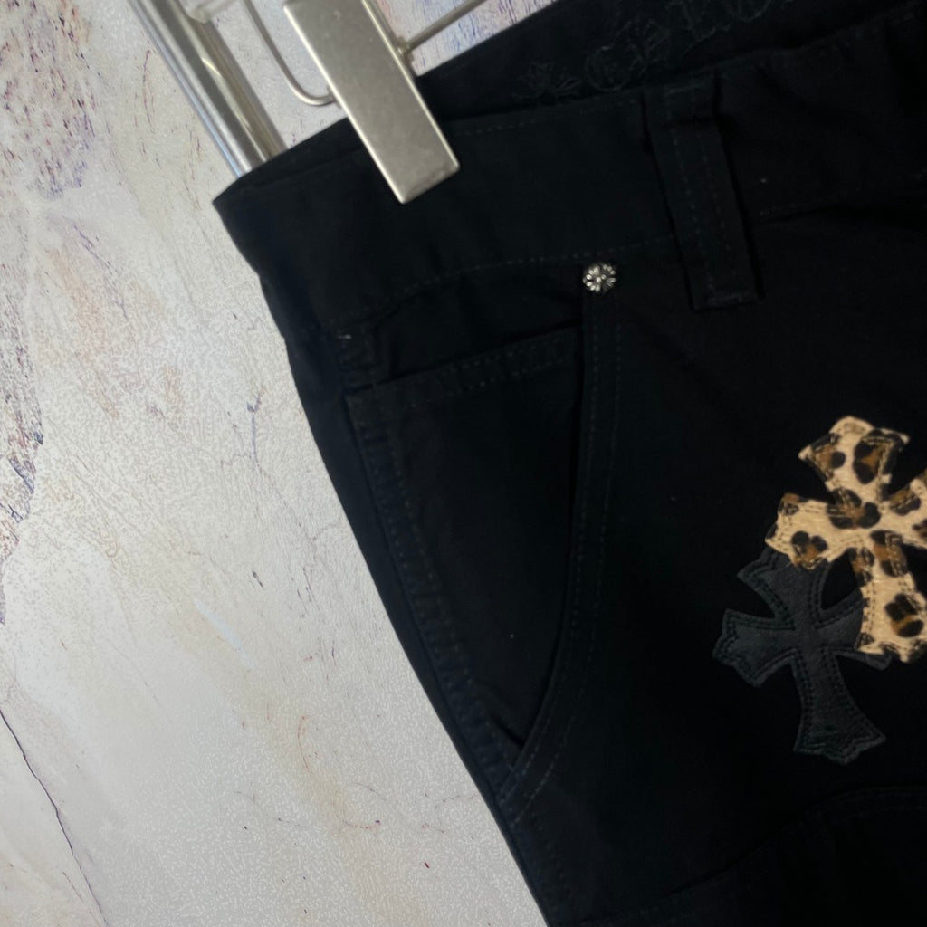 Black pants with side pocket and gold cross applique near the hem