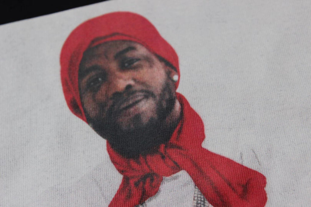 Stussy T-shirt print close-up with red-hat portrait graphic