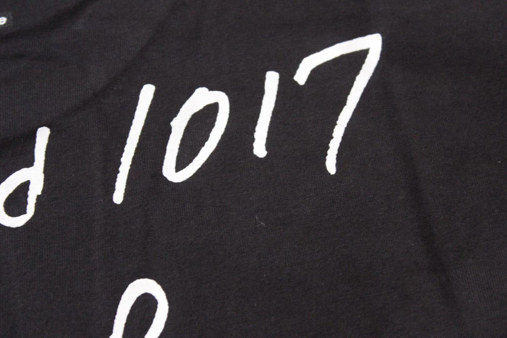 Stussy black T-shirt print close-up with '1017' lettering