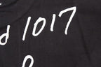 Stussy black T-shirt print close-up with '1017' lettering