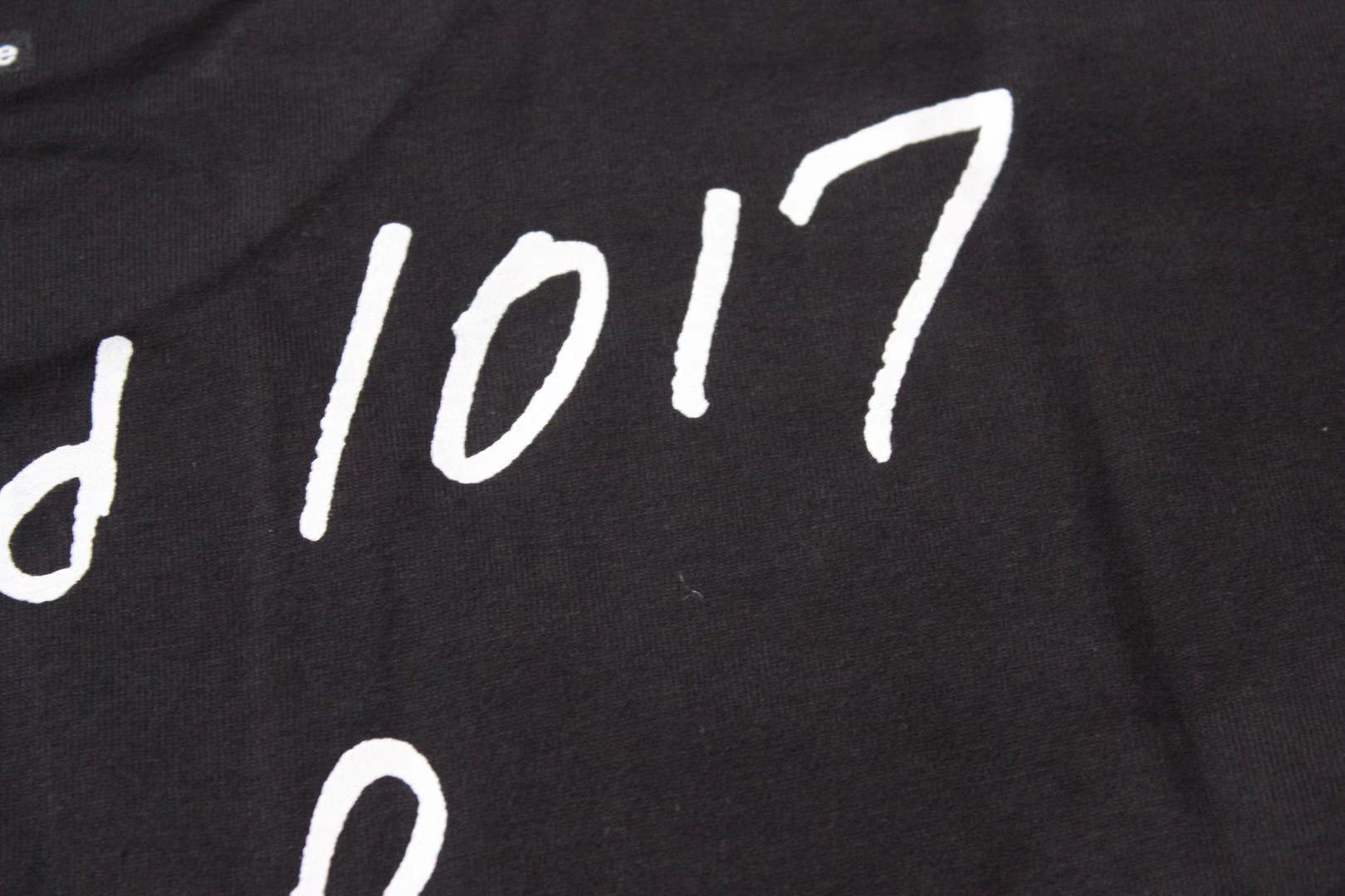 Stussy black T-shirt print close-up with '1017' lettering