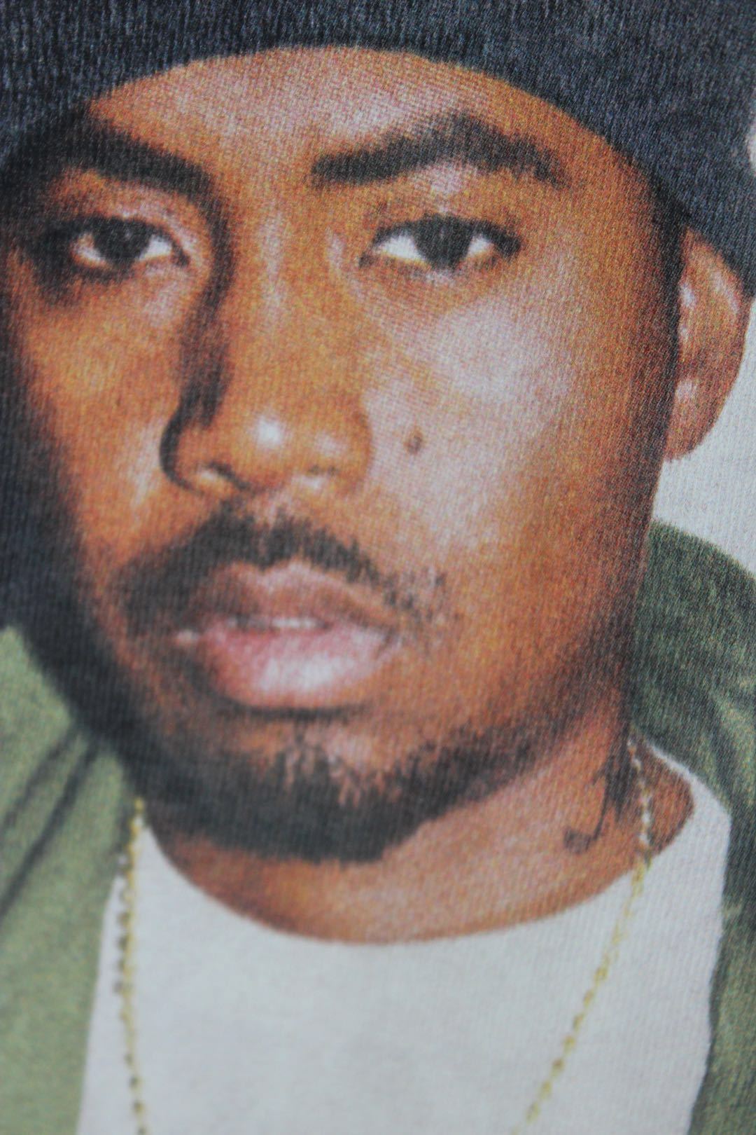 Graphic T-shirt close-up: face portrait in beanie with Nasty Nas text