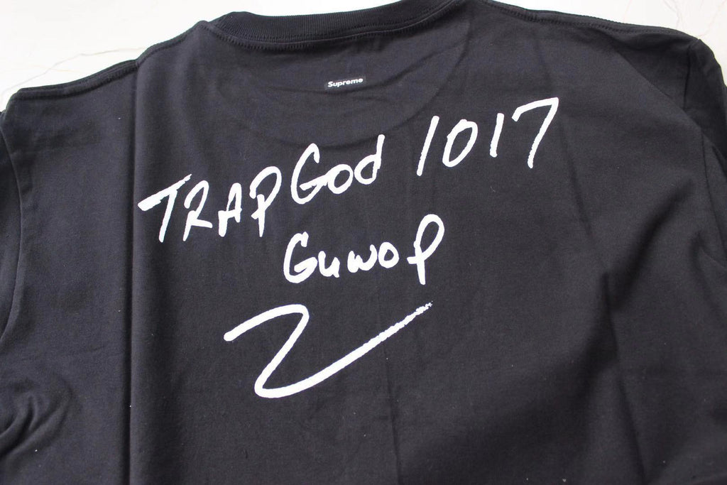 Stussy black T-shirt back close-up: 'Trap God 1017' and 'GunvoP' text