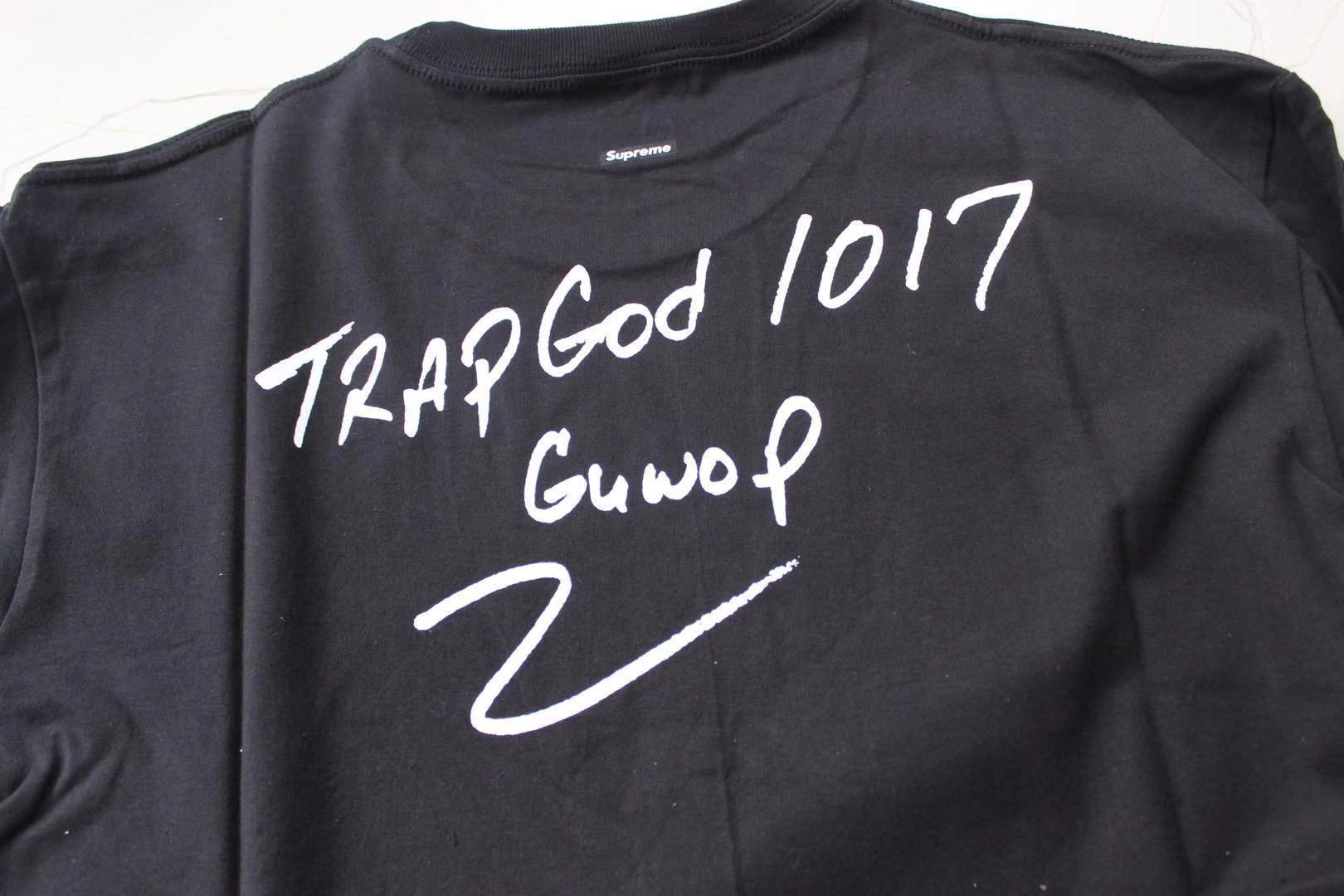 Stussy black T-shirt back close-up: 'Trap God 1017' and 'GunvoP' text