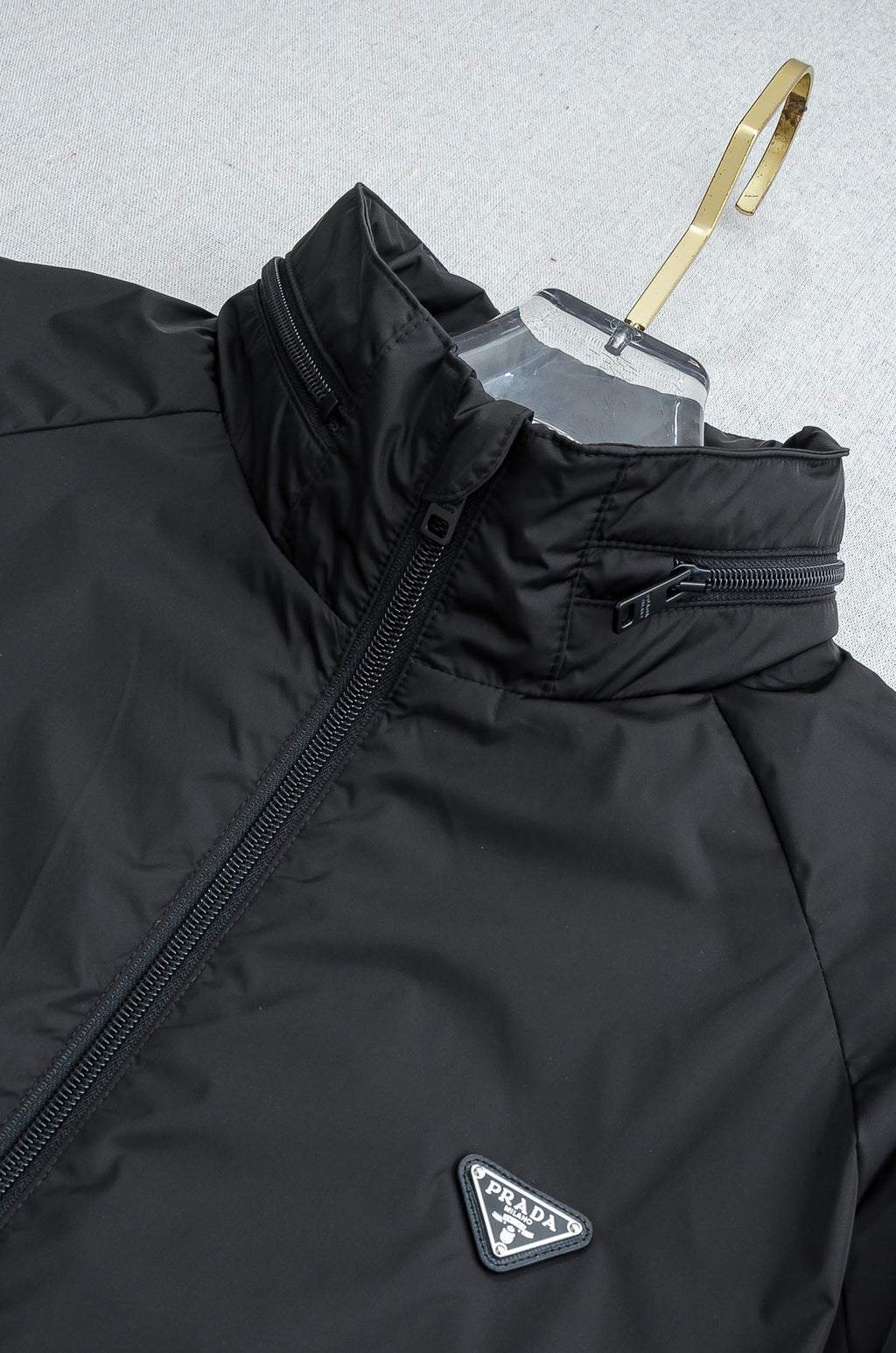 Prada long jacket with hooded stand collar, front zipper, and Prada triangle badge