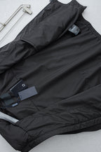 Prada long jacket laid flat with dark outer fabric and attached product tags