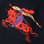 Close-up of red, blue, and yellow embroidered polo player graphic on dark navy sweatshirt