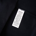 Dark navy sweatshirt fabric close-up with white interior care and size label