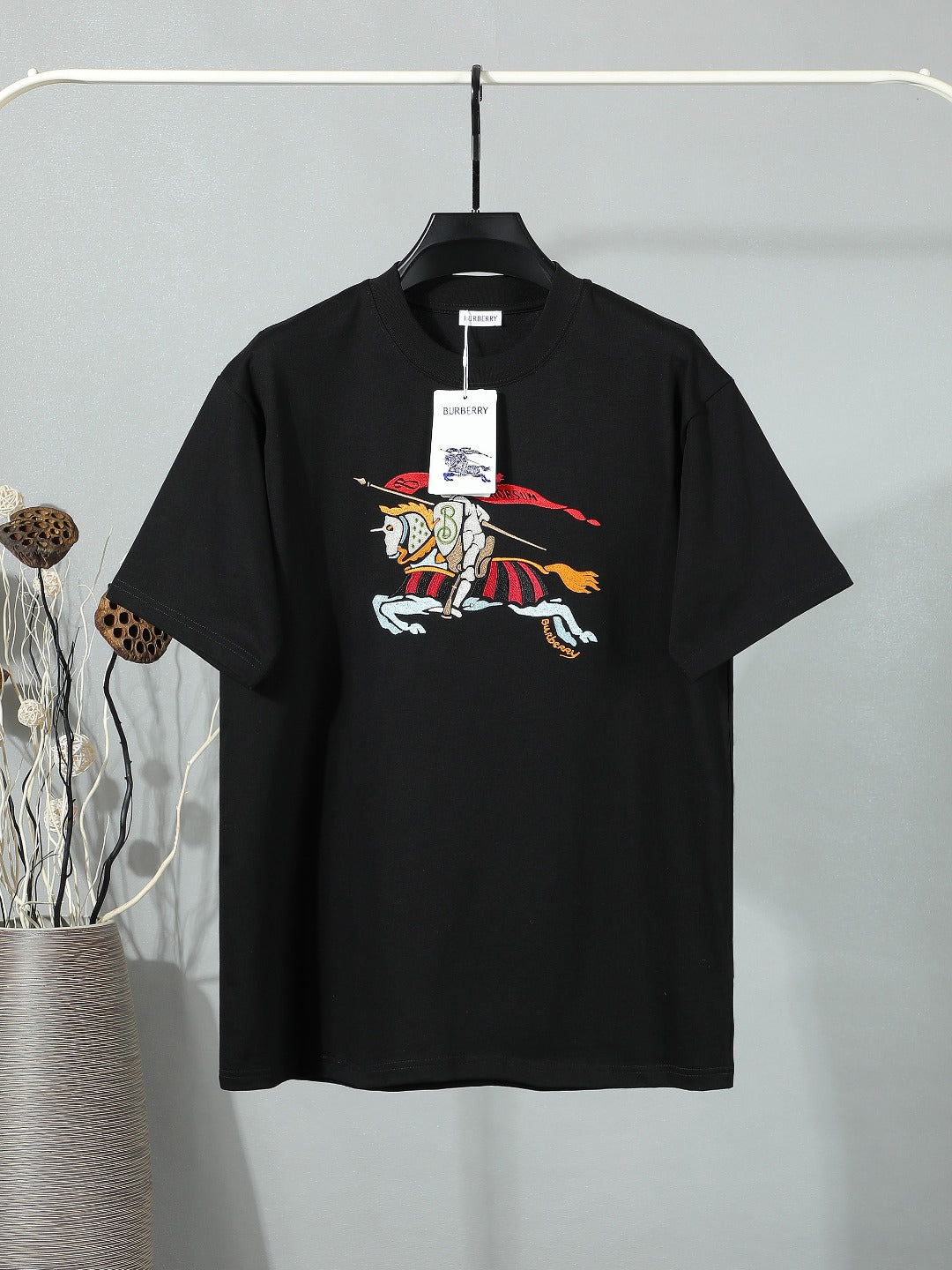 Black short-sleeve T-shirt with colorful horse-and-rider graphic at chest.